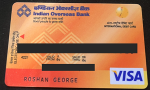 A picture of an Indian Overseas Bank Debit card, served through visa. It has the number and validity period redacted.